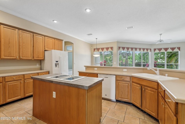 2260 Harbor Lake Dr, Fleming Island, FL 32003 - kitchen with white appliances, a center island, a sink, light tile patterned floors, and arched walkways