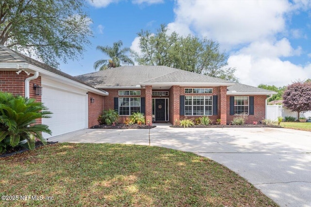 view of front of house with brick siding, a garage, driveway, and a front yard
