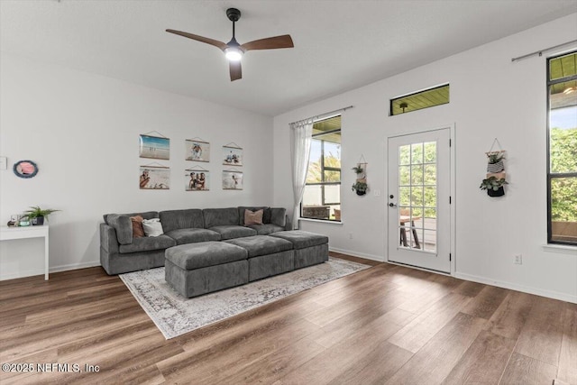 living room with wood finished floors, ceiling fan, and baseboards