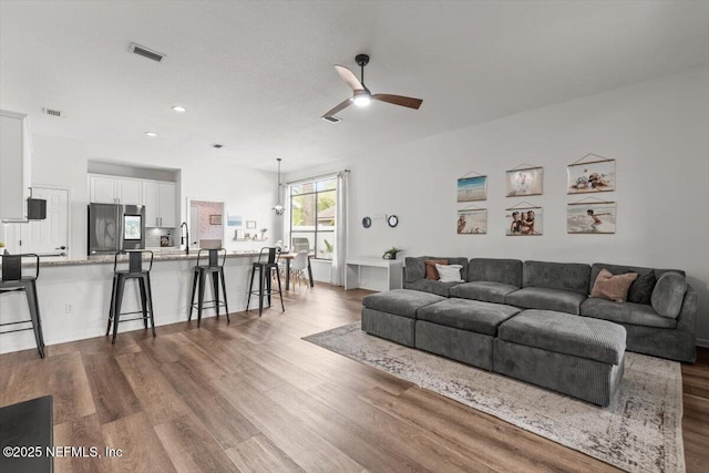 living room featuring a ceiling fan, dark wood finished floors, and recessed lighting