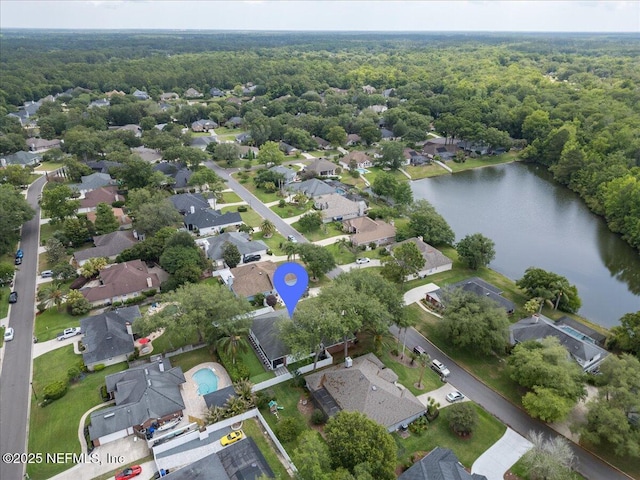 view of property location with a forest, a large body of water, and nearby suburban area