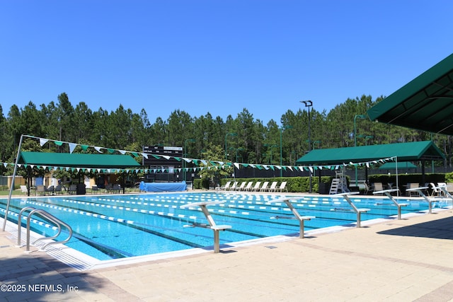 community pool with fence and a patio