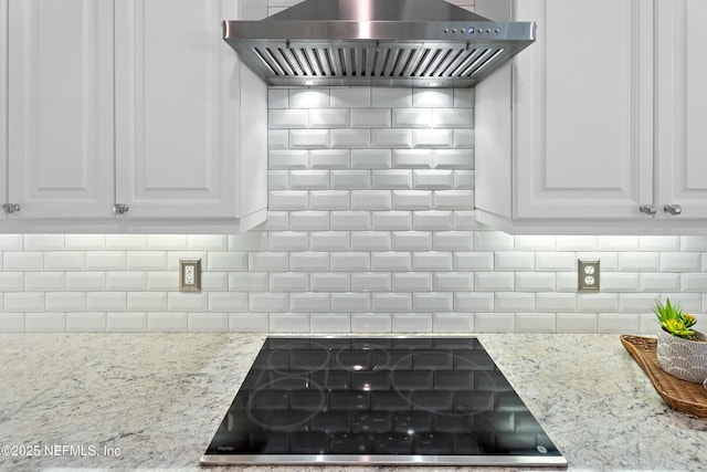 389 Summerset Dr, Saint Johns, FL 32259 - kitchen view of black electric cooktop, wall chimney exhaust hood, tasteful backsplash, and white cabinetry