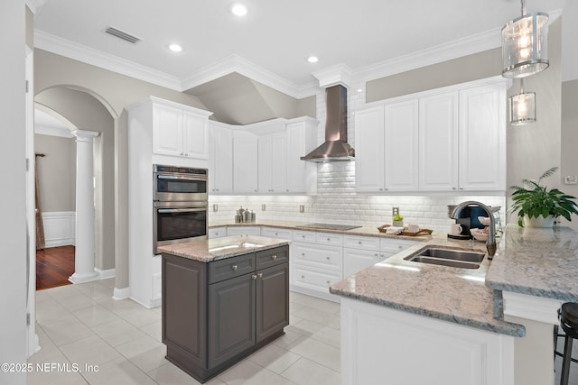 389 Summerset Dr, Saint Johns, FL 32259 - kitchen featuring a sink, decorative columns, white cabinets, arched walkways, and ornamental molding
