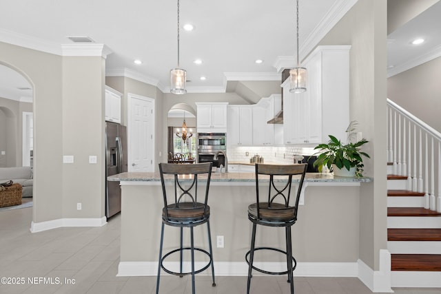 389 Summerset Dr, Saint Johns, FL 32259 - kitchen featuring a peninsula, arched walkways, stainless steel appliances, light stone counters, and recessed lighting