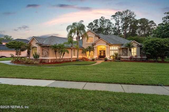 389 Summerset Dr, Saint Johns, FL 32259 - view of front of house with stucco siding, a lawn, and stone siding