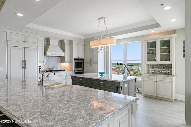 932 1st St N Unit 902, Jacksonville Beach, FL 32250 - kitchen with a sink, premium range hood, a spacious island, tasteful backsplash, and recessed lighting