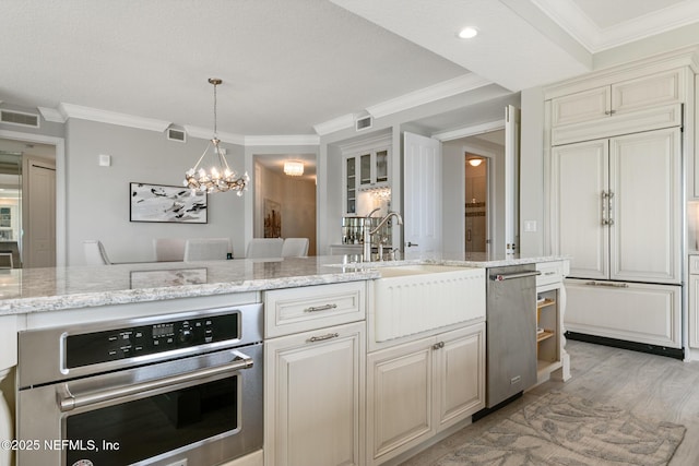 932 1st St N Unit 902, Jacksonville Beach, FL 32250 - kitchen featuring appliances with stainless steel finishes, ornamental molding, a sink, light wood-style flooring, and light stone counters