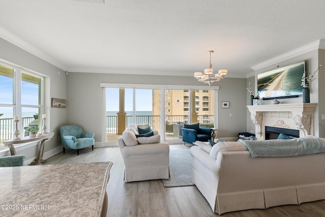 932 1st St N Unit 902, Jacksonville Beach, FL 32250 - living area with a chandelier, crown molding, plenty of natural light, light wood finished floors, and a fireplace