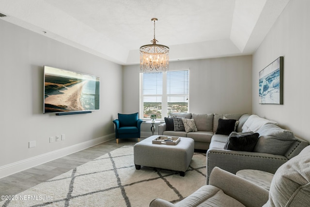 932 1st St N Unit 902, Jacksonville Beach, FL 32250 - living area featuring a tray ceiling, a chandelier, wood finished floors, and baseboards