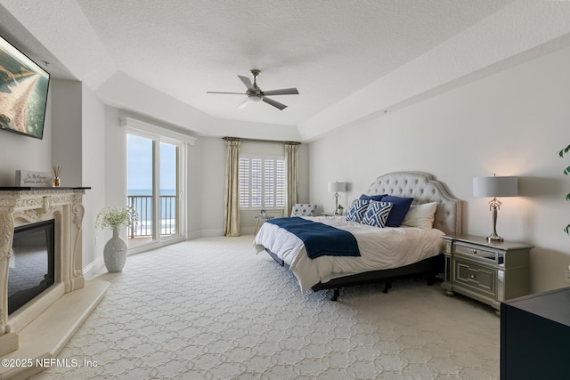 932 1st St N Unit 902, Jacksonville Beach, FL 32250 - bedroom featuring light carpet, access to exterior, a high end fireplace, a textured ceiling, and a ceiling fan