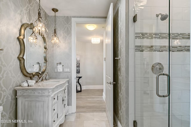932 1st St N Unit 902, Jacksonville Beach, FL 32250 - full bathroom featuring a stall shower, vanity, wallpapered walls, a chandelier, and baseboards