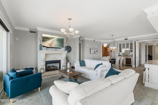 932 1st St N Unit 902, Jacksonville Beach, FL 32250 - living area with a chandelier, light wood finished floors, ornamental molding, a fireplace with raised hearth, and beverage cooler