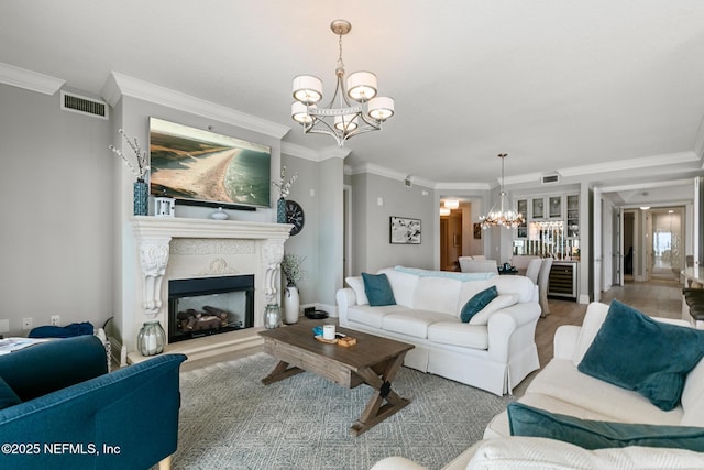 932 1st St N Unit 902, Jacksonville Beach, FL 32250 - living area featuring a chandelier, ornamental molding, a fireplace with raised hearth, and wood finished floors