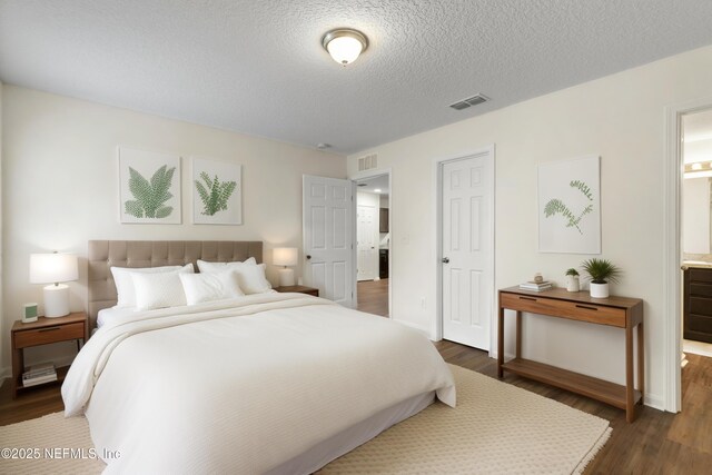 1343 Pangola Dr, Jacksonville, FL 32205 - bedroom with dark wood-type flooring, a textured ceiling, and ensuite bath