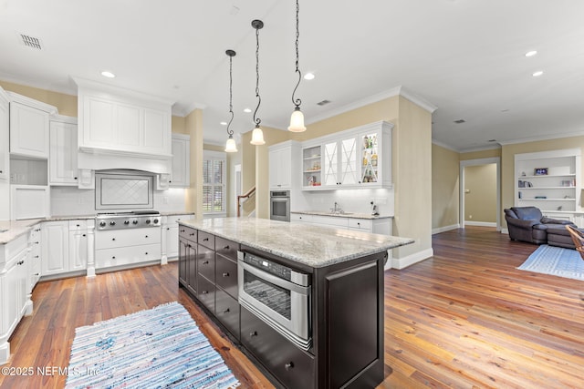 kitchen with appliances with stainless steel finishes, open shelves, white cabinetry, open floor plan, and decorative backsplash