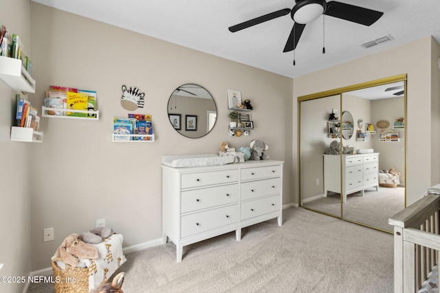 bedroom with light carpet, a closet, baseboards, and a ceiling fan