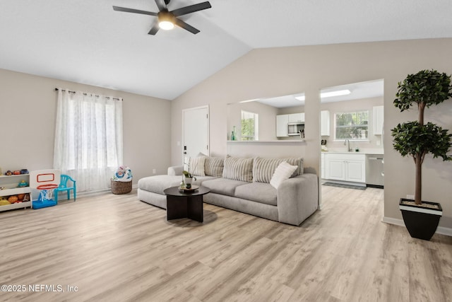 living area with a ceiling fan, light wood-style floors, and lofted ceiling
