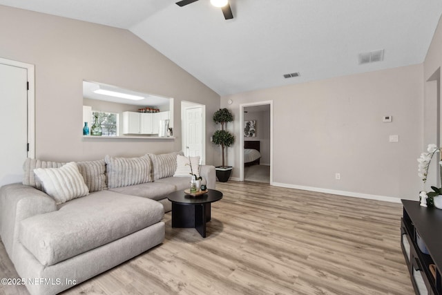 living area with lofted ceiling, ceiling fan, light wood-type flooring, and baseboards