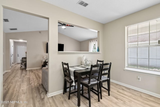 dining room with wood finished floors, baseboards, and lofted ceiling