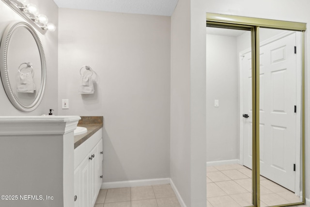 bathroom with vanity, tile patterned floors, and baseboards