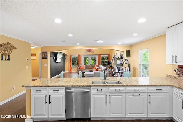 221 Thornloe Dr, Saint Johns, FL 32259 - kitchen with stainless steel dishwasher, a sink, a peninsula, dark wood-style flooring, and white cabinets
