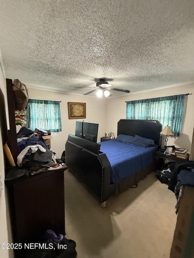 carpeted bedroom featuring a ceiling fan and a textured ceiling