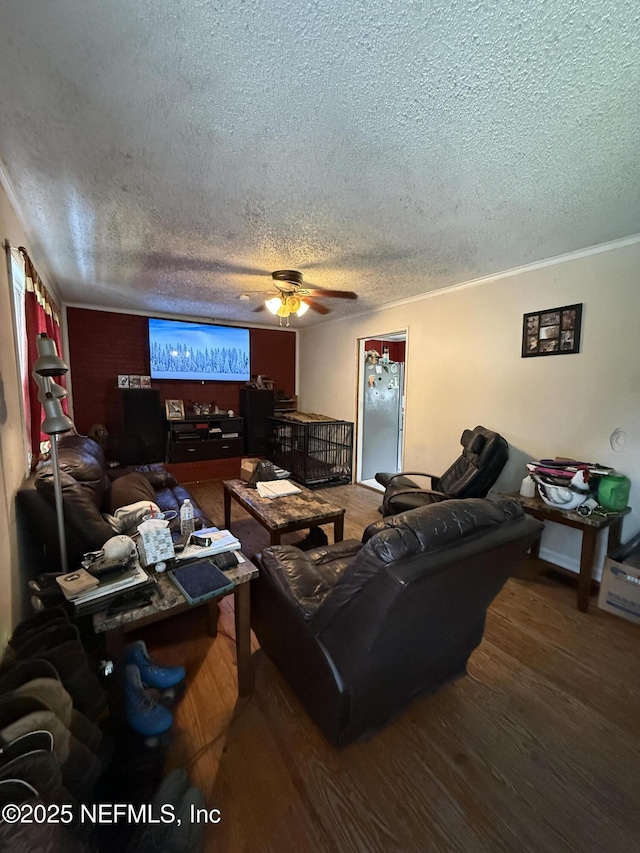 living area with a textured ceiling, a ceiling fan, and wood finished floors
