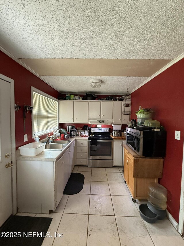kitchen featuring appliances with stainless steel finishes, a textured ceiling, a sink, light countertops, and crown molding