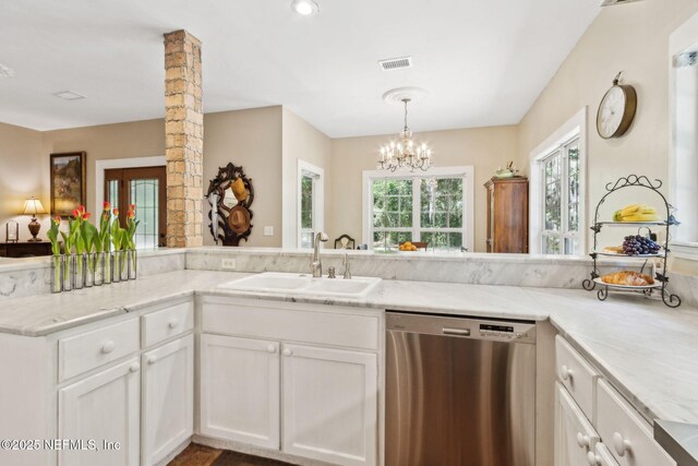 96448 Marsh Hen Rd, Fernandina Beach, FL 32034 - kitchen with stainless steel dishwasher, a sink, white cabinetry, a chandelier, and pendant lighting