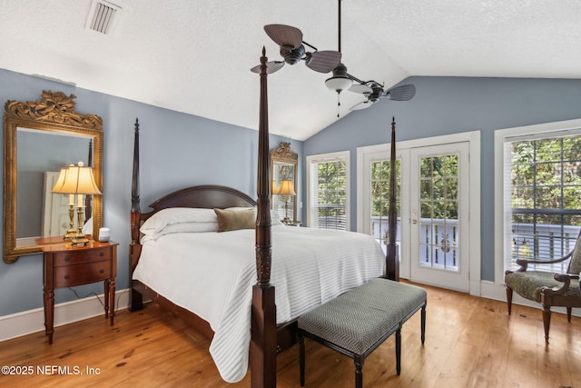 96448 Marsh Hen Rd, Fernandina Beach, FL 32034 - bedroom with access to outside, vaulted ceiling, multiple windows, light wood finished floors, and baseboards