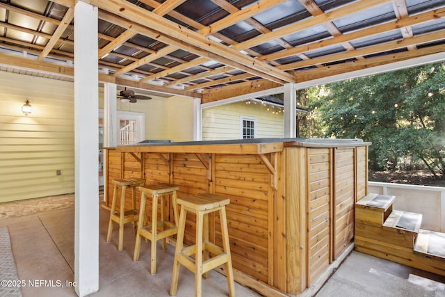 96448 Marsh Hen Rd, Fernandina Beach, FL 32034 - indoor dry bar featuring wood walls, a ceiling fan, and concrete floors