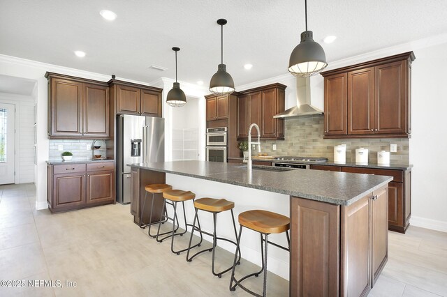 334 Continuum Loop, Yulee, FL 32097 - kitchen with wall chimney exhaust hood, stainless steel appliances, dark countertops, a sink, and backsplash