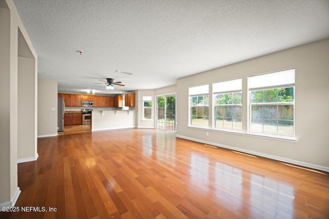12198 Pebble Point Dr S, Jacksonville, FL 32218 - unfurnished living room with wood finished floors, ceiling fan, baseboards, and a textured ceiling