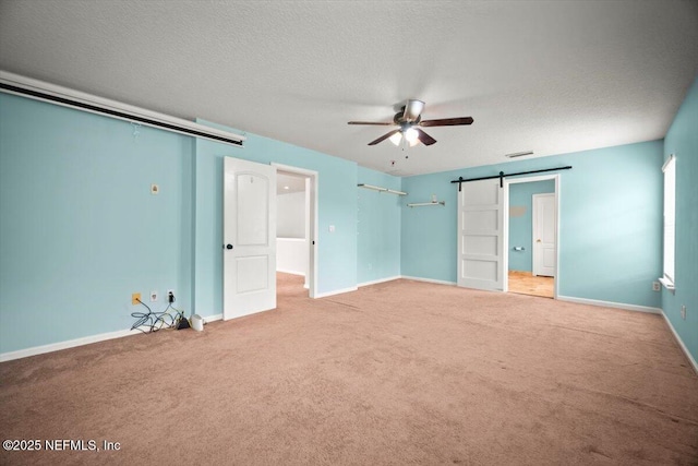12198 Pebble Point Dr S, Jacksonville, FL 32218 - unfurnished bedroom with carpet floors, baseboards, a barn door, a textured ceiling, and a ceiling fan