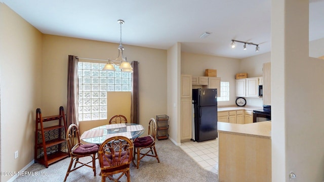 dining room with track lighting, baseboards, and light tile patterned flooring