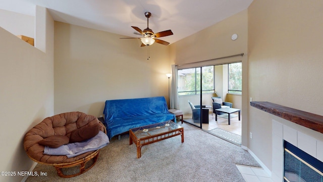 living area featuring carpet, a ceiling fan, and a fireplace