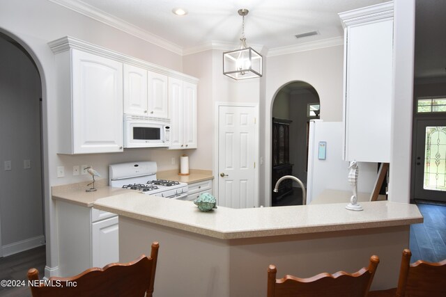 kitchen with white appliances, arched walkways, dark wood-type flooring, white cabinets, and crown molding