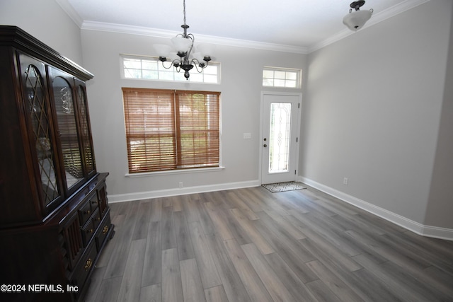 foyer with a chandelier, crown molding, wood finished floors, and baseboards