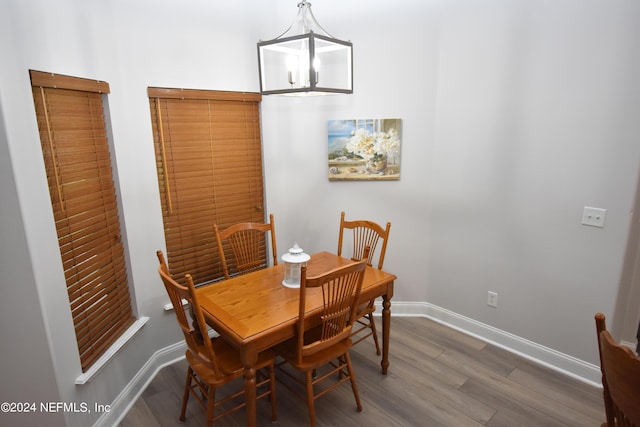 dining room with wood finished floors, baseboards, and a chandelier