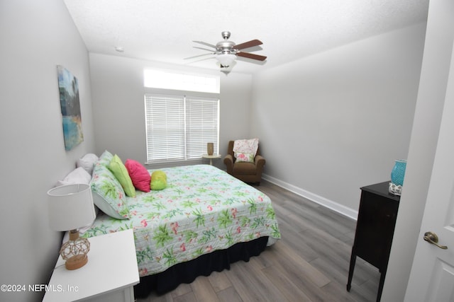 bedroom with wood finished floors, baseboards, and a ceiling fan