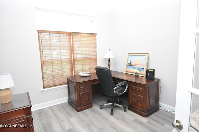 office space featuring baseboards, light wood-type flooring, and plenty of natural light