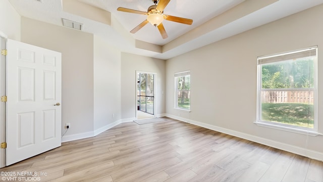 96069 Hidden Marsh Ln, Fernandina Beach, FL 32034 - unfurnished room featuring light wood-type flooring, baseboards, ceiling fan, and a tray ceiling