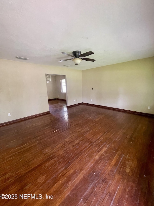 spare room with wood-type flooring, ceiling fan, and baseboards