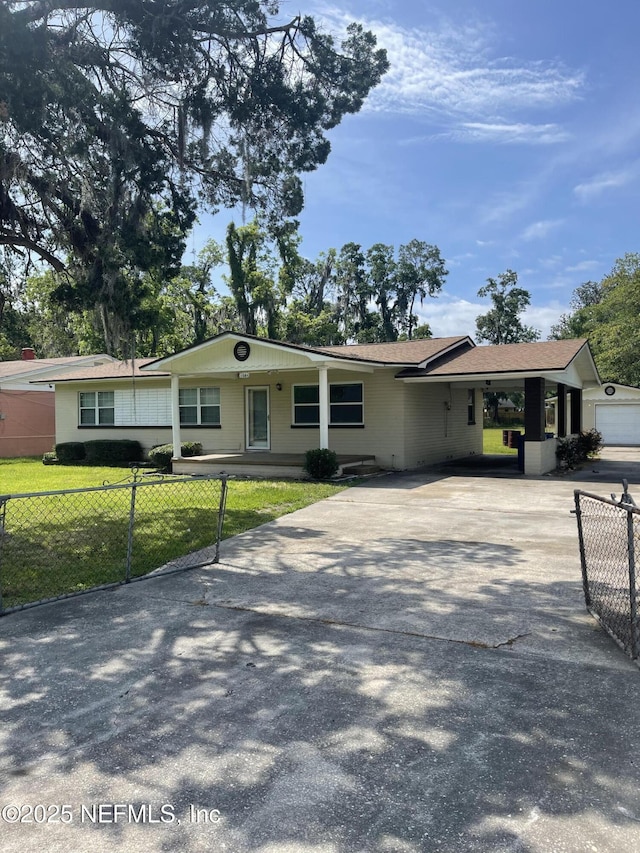 ranch-style home featuring concrete driveway and a carport