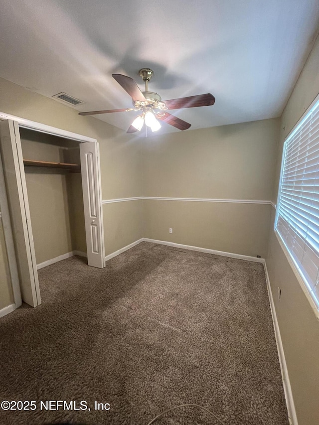 unfurnished bedroom with a closet, carpet flooring, baseboards, and ceiling fan