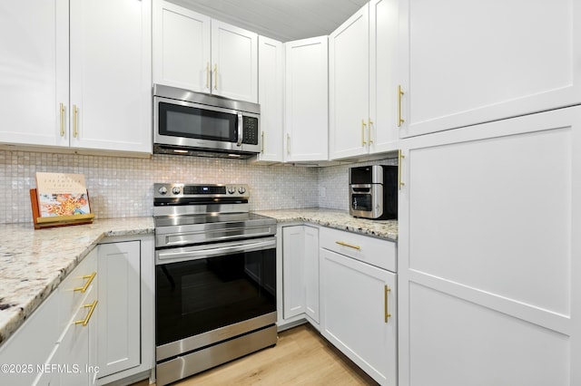626 Ponte Vedra Blvd Unit B6, Ponte Vedra Beach, FL 32082 - kitchen featuring stainless steel appliances, white cabinets, decorative backsplash, and light stone countertops