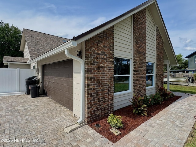 946 Cedar Ridge Ct, Orange Park, FL 32065 - view of home's exterior featuring an attached garage, brick siding, fence, and decorative driveway