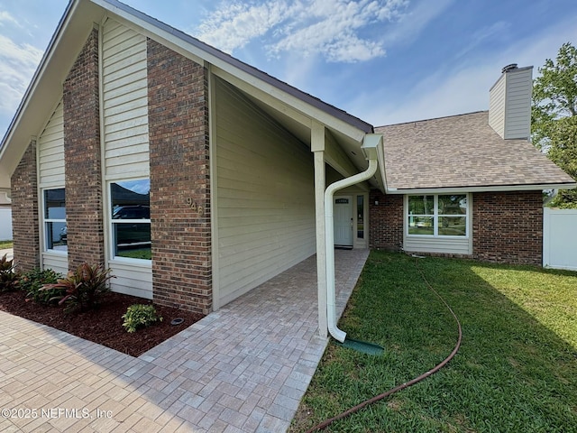 946 Cedar Ridge Ct, Orange Park, FL 32065 - view of side of property featuring brick siding, a yard, roof with shingles, and a chimney