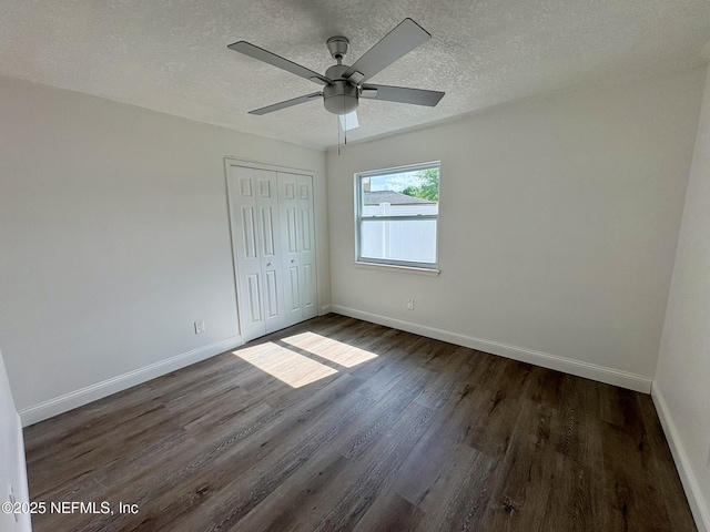 946 Cedar Ridge Ct, Orange Park, FL 32065 - unfurnished bedroom featuring baseboards, dark wood-style flooring, a closet, a textured ceiling, and a ceiling fan